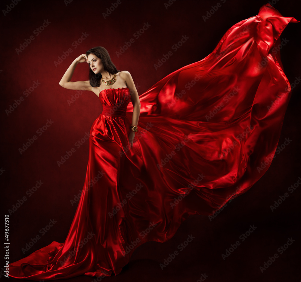 Fototapeta Woman in red waving dress dancing with flying fabric