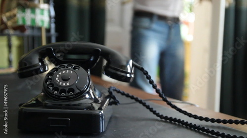 Vintage black telephone. Man dials 
