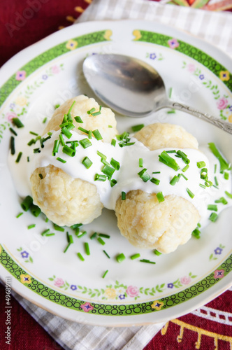 Boiled potato dumplings with sour cream and herbs