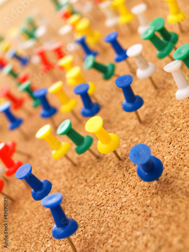 Colorful thumbtacks on cork board