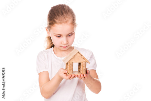Beautiful little girl holding a toy model house.