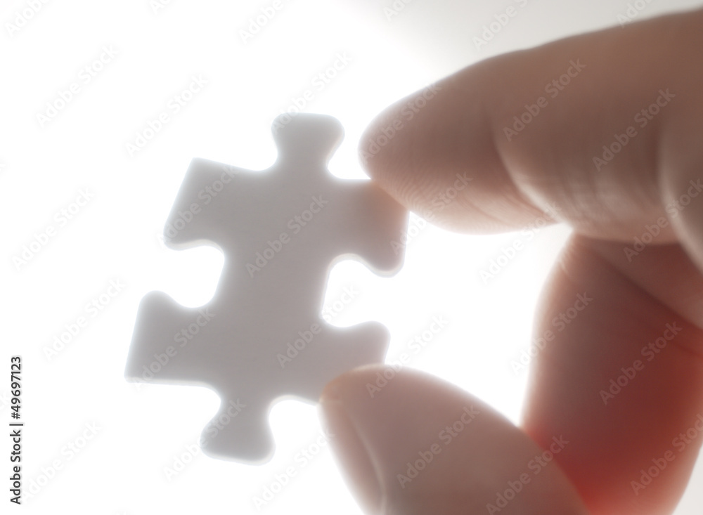 Obraz premium A person picking up one puzzle pieces against the light.(horizon