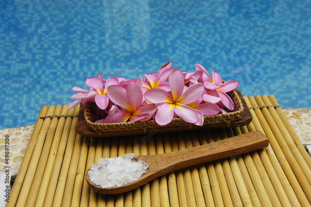 frangipani in bowl of with salt in spoon on bamboo mat frangipani in bowl of with salt in spoon on bamboo mat