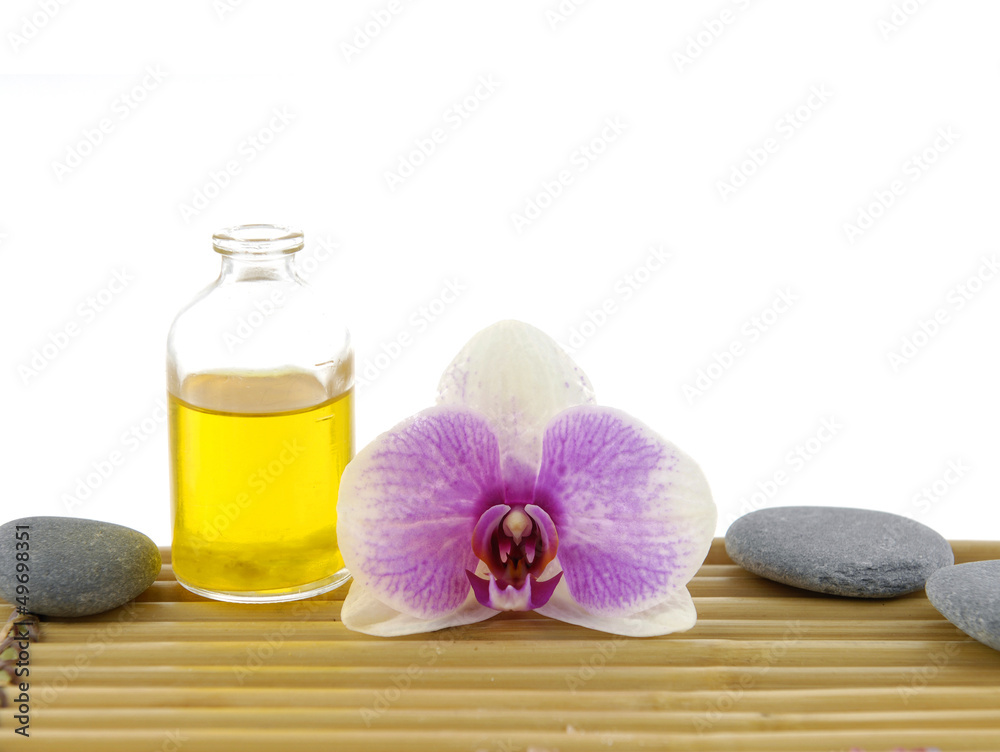 Macro of gorgeous orchid and stones with massage oil on mat Macro of gorgeous orchid and stones with massage oil on mat