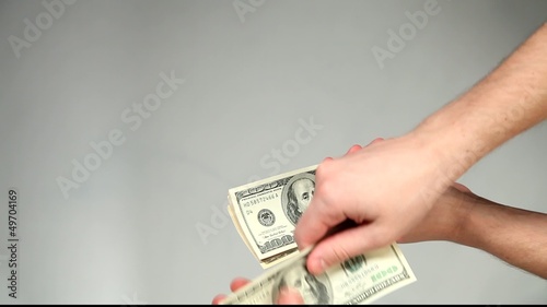 Hands giving and taking dollars on grey background