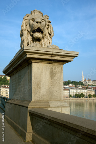 Guardian lion statue on famous Chain Bridge in Budapest