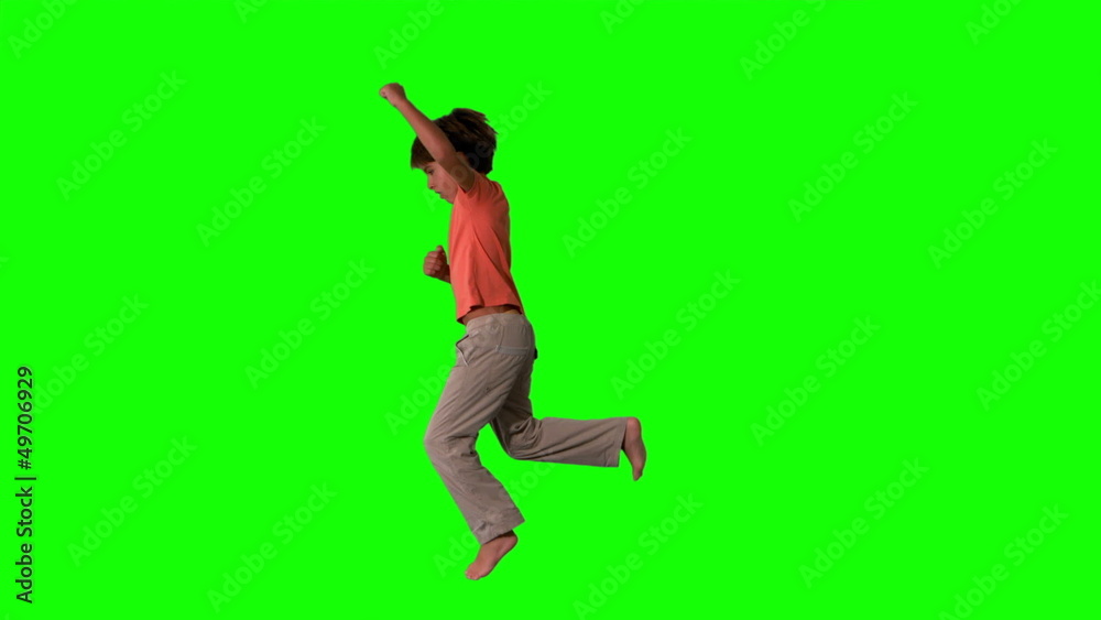 Side view of boy jumping up on green screen Side view of boy jumping up on green screen