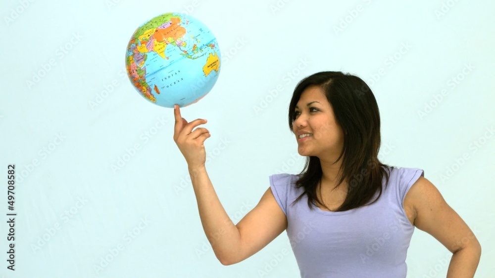Smiling woman spinning globe on finger Smiling woman spinning globe on finger