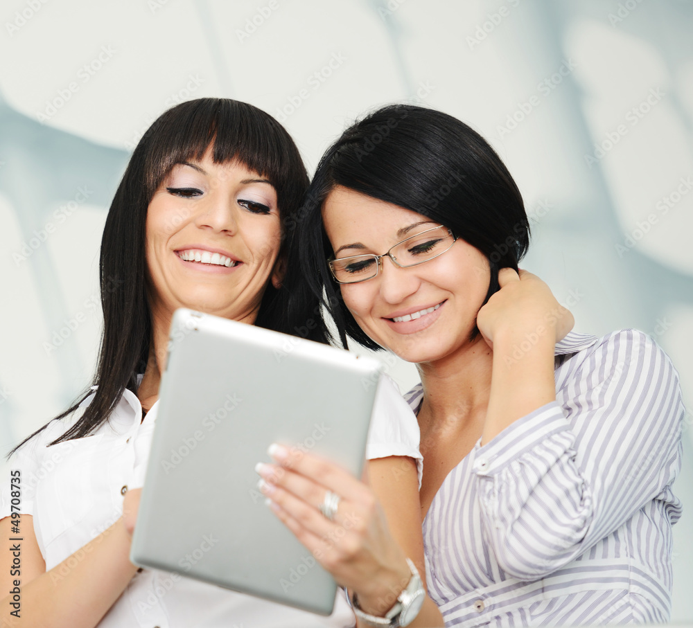 Two businesswomen working on tablet gadget with copy space Two businesswomen working on tablet gadget with copy space