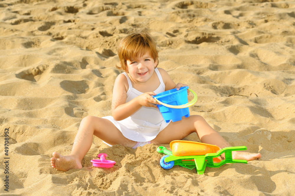 Happy toddler girl playing with her toys at beach Happy toddler girl playing with her toys at beach