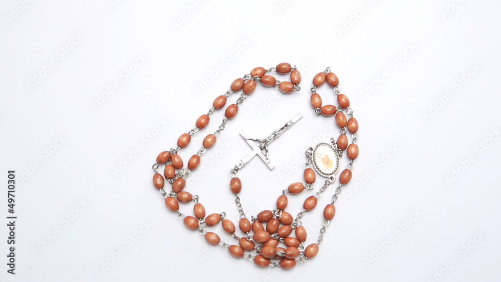 Rosary beads on white surface Rosary beads on white surface