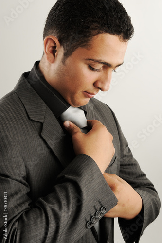 Profile photo of a businessman adjusting his tie