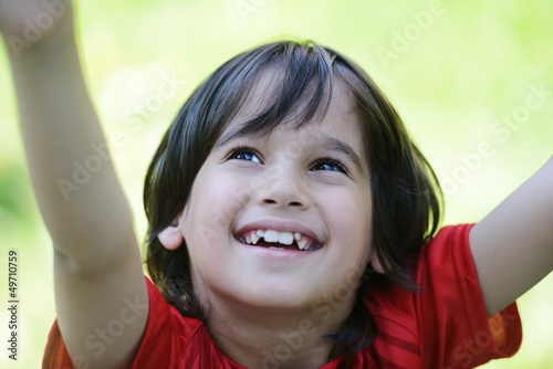 Closeup portrait of a little happy boy outside