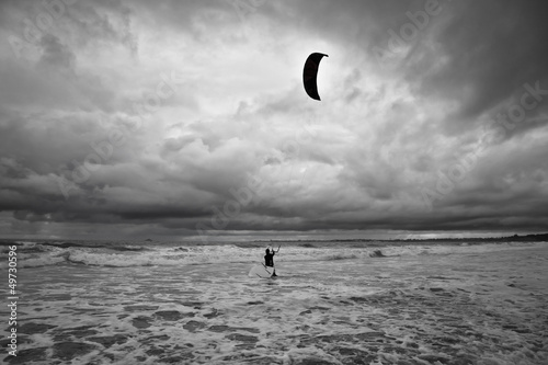 Kitesurfer gets in the water during a storm.