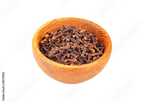 Clove spice in wooden bowl, isolated on white background