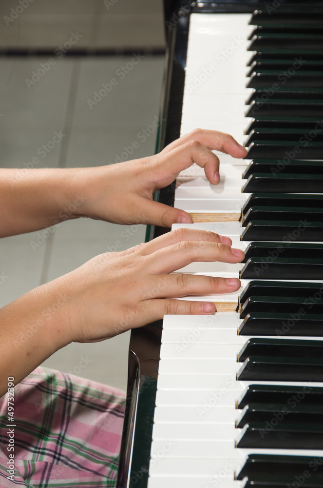 Close up of child's hands playing the piano.. Close up of child's hands playing the piano..