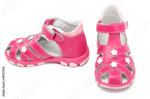 Pink child's sandals isolated on white.