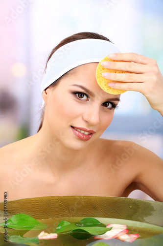 Young woman washing her fac...