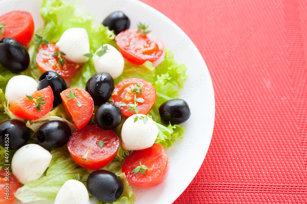 Caprese salad with tomato and mozzarella cheese on a white plate