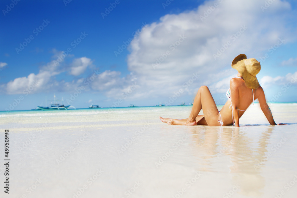 young beautiful woman relaxing on sand beach