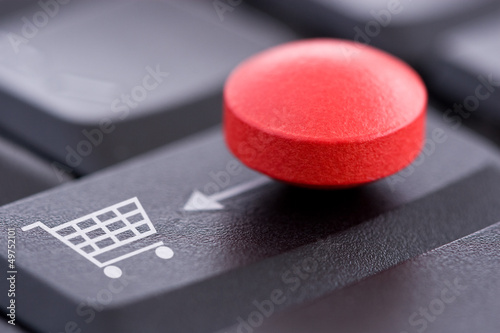 Red Pill and Shopping Cart on Computer Keyboard photo