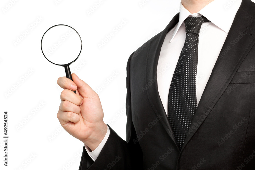 Isolated businessman in a suit holding a magnifying glass