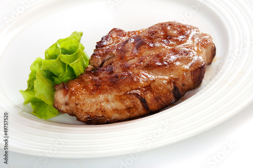 Grilled steak meat on a white plate
