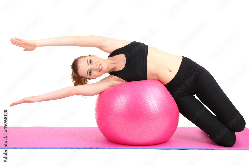 Fototapeta premium Young woman doing fitness exercises with gym ball isolated