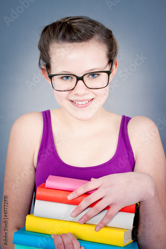 Teenager Mädchen mit großer Brille und vielen Büchern