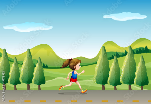 A girl jogging at the street with trees