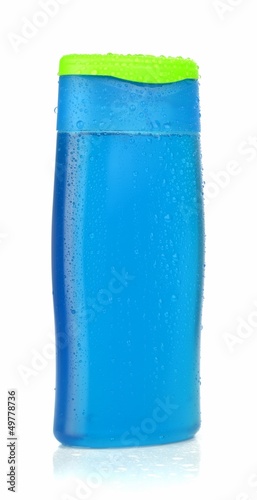 A wet bottle of shower gel shampoo on a white background