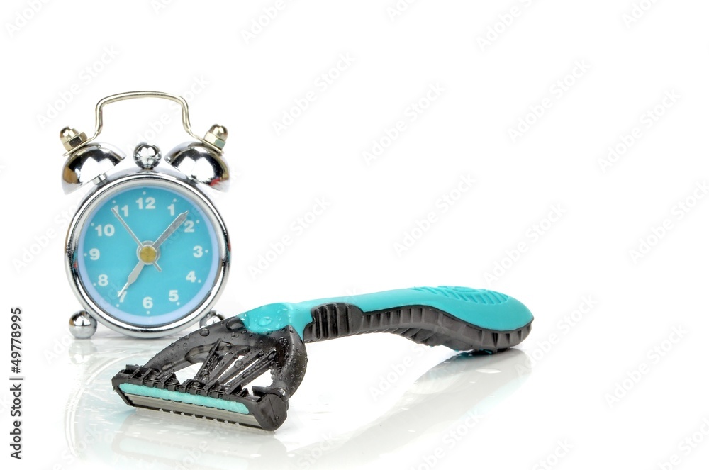 A disposable razor next to a mini alarm clock. Morning routine A disposable razor next to a mini alarm clock. Morning routine