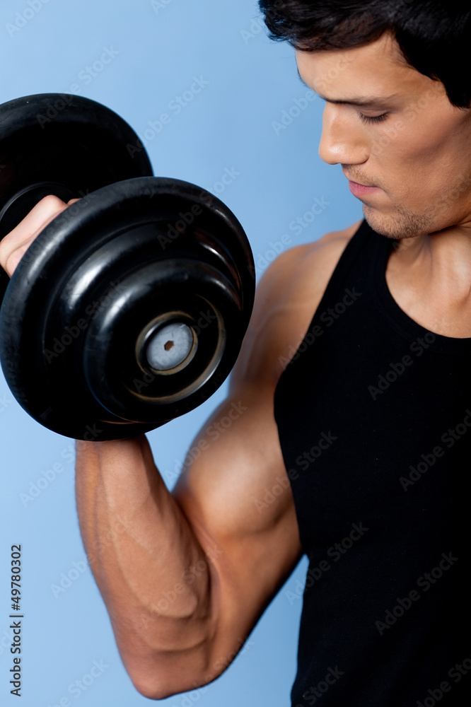 Handsome muscular man uses his dumbbell Handsome muscular man uses his dumbbell