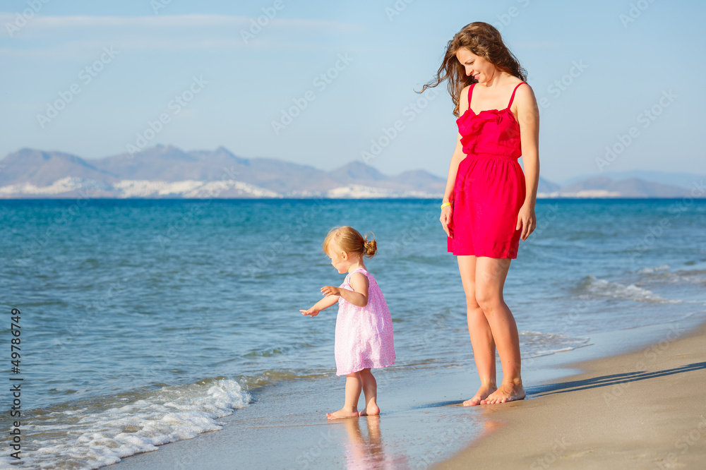 Mother with little daughter on the beach