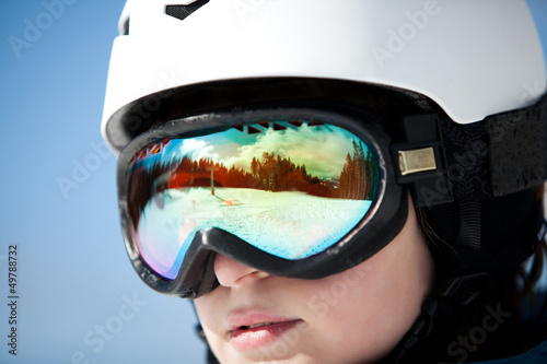 female snowboarder against sun and blue sky