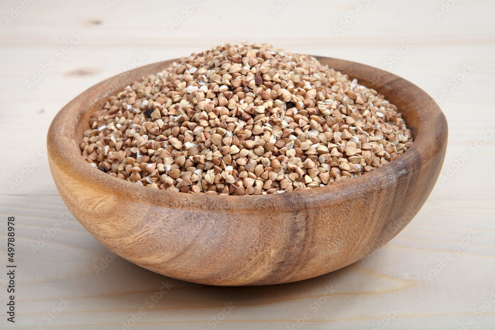 a bowl of buckwheat on wooden surface a bowl of buckwheat on wooden surface