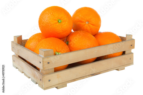 Fresh and ripe orange fruits in a wooden crate isolated