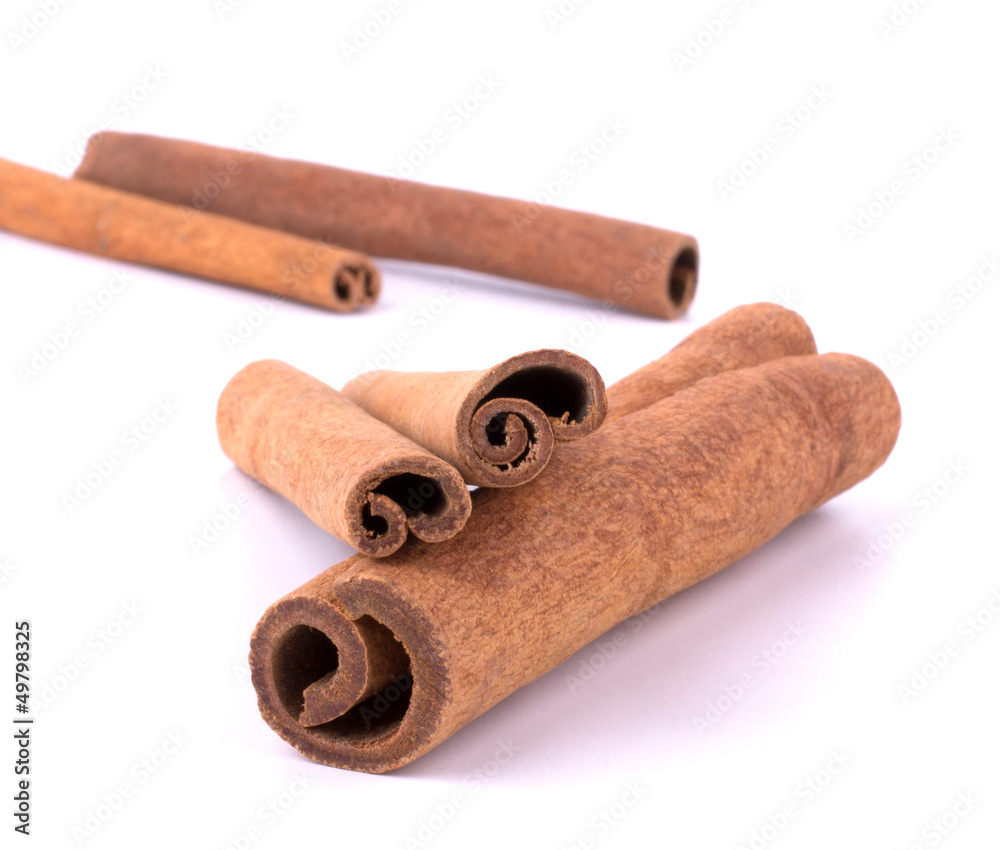 Cinnamon sticks stacked on white background