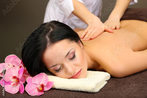 Beautiful young woman in spa salon getting massage with spa