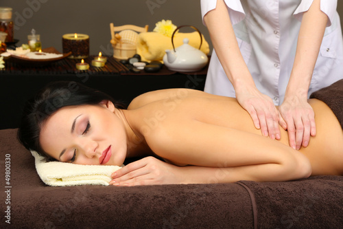 Beautiful young woman in spa salon getting massage,