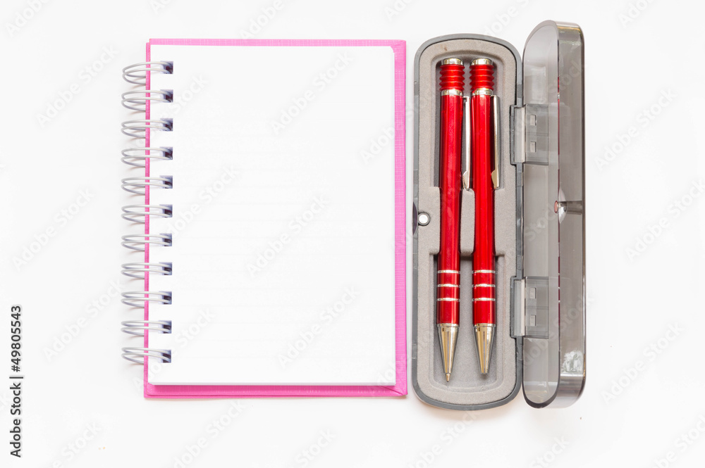 pink notebook with two red pen in box on white background pink notebook with two red pen in box on white background