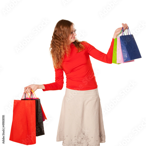 Shopping woman in glasses holding many shopping bags