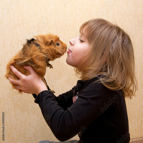 The little girl kissing the guinea pig.