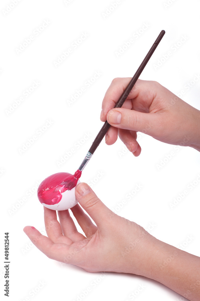 Female hand colored Easter egg pink paint and brush isolated Female hand colored Easter egg pink paint and brush isolated