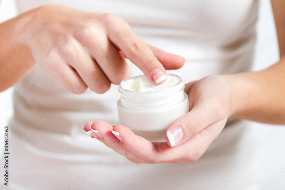 Body care. Woman applying cream on hands