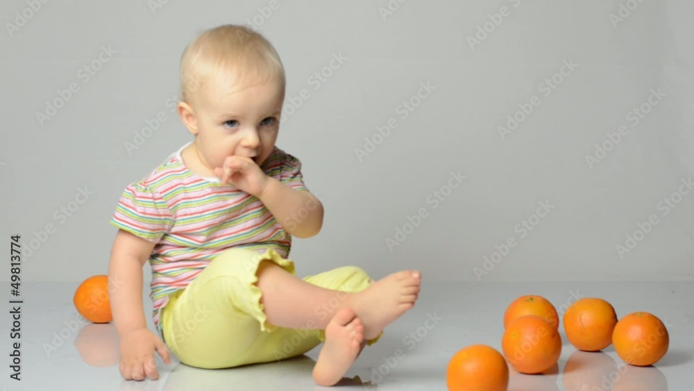 baby playing with oranges