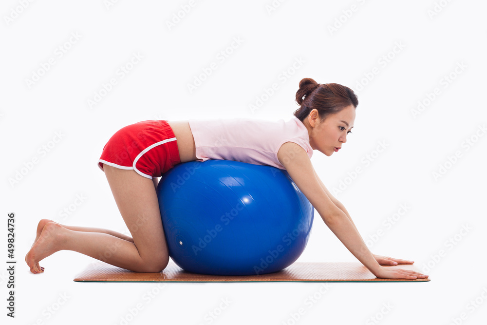 Fototapeta premium Young woman with gym ball isolated on white