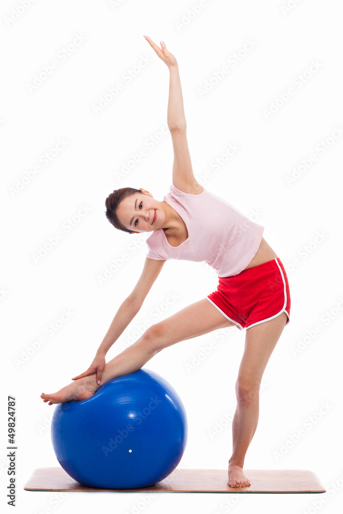 Fototapeta premium Young woman with gym ball isolated on white