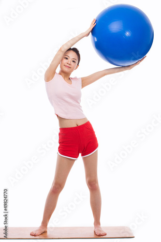 Young woman with gym ball isolated on white