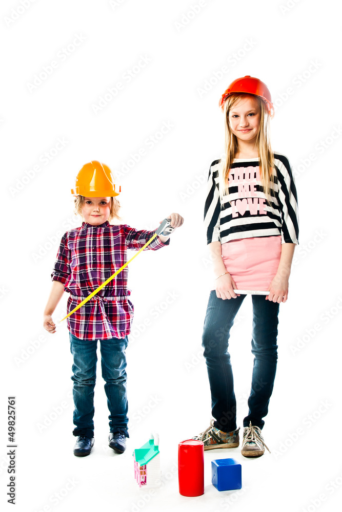 Two young beautiful girls in building helmet and tools in hand Two young beautiful girls in building helmet and tools in hand